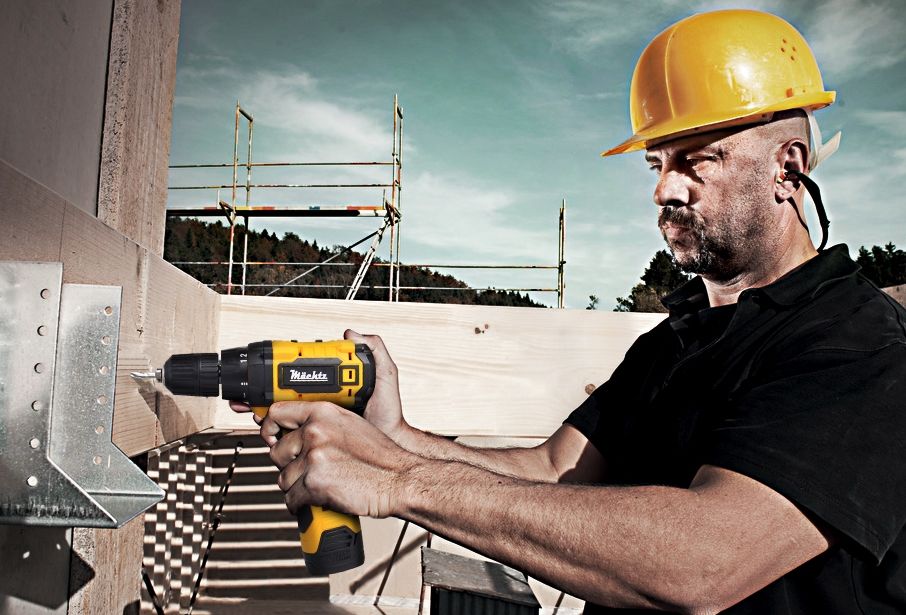 Будівельник працює шуруповертом