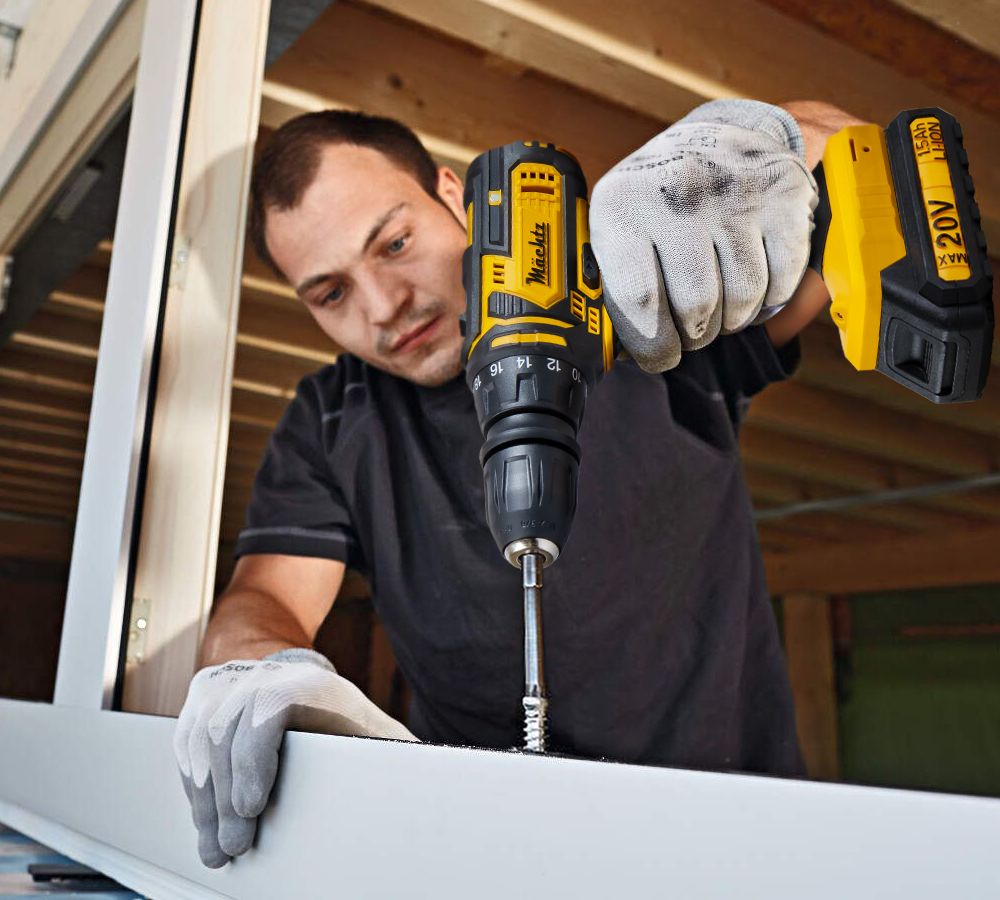 Мужчина закручивает шуруп шуруповертом