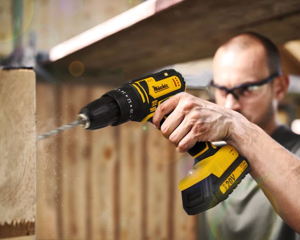 Мужчина сверлит деревянную балку