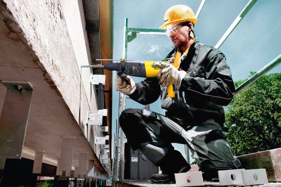 Мужчина работает перфоратором на стройке