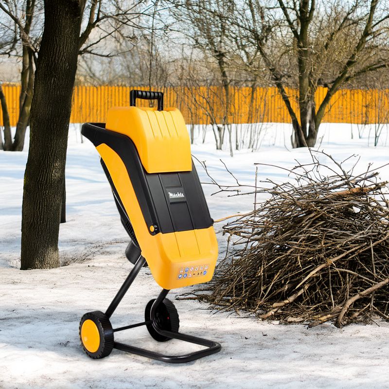 Подрібнювач гілок Machtz поруч із купою гілок