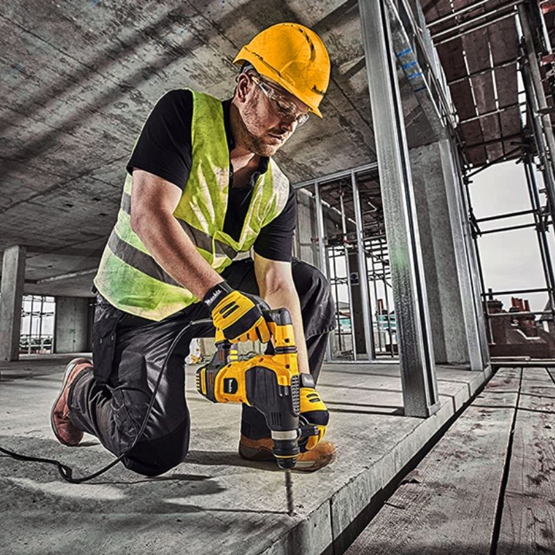 Строитель сверлит бетонный пол перфоратором Mächtz