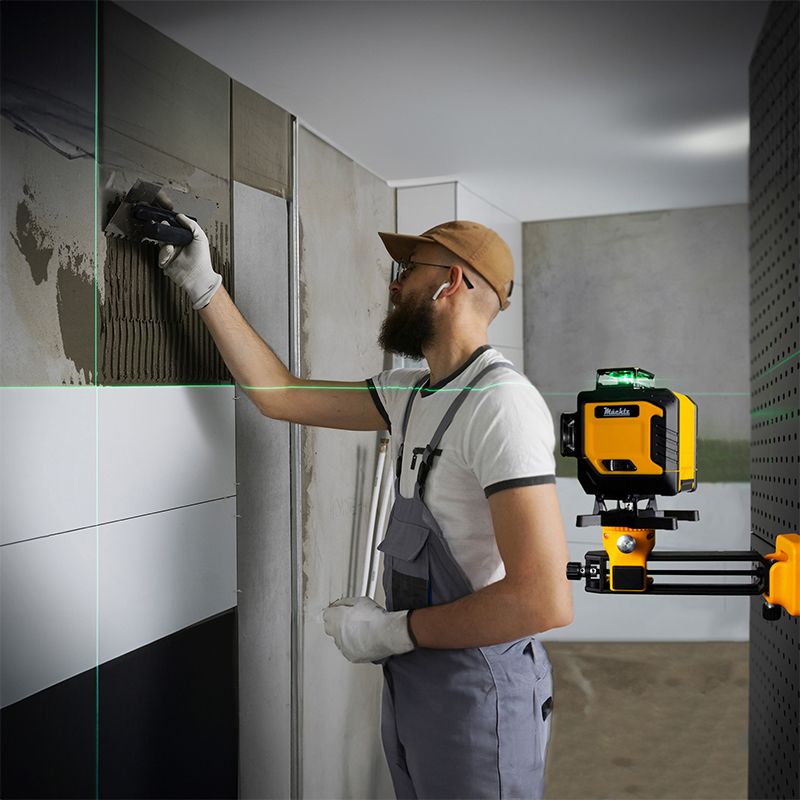 Майстер кладе плитку за допомогою лазерного рівня