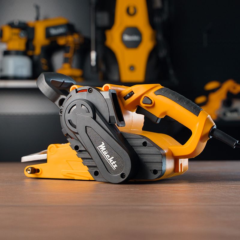 Человек использует ленточную шлифмашину