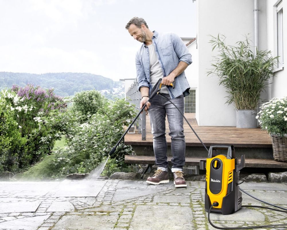 Мужчина моет плитку мойкой