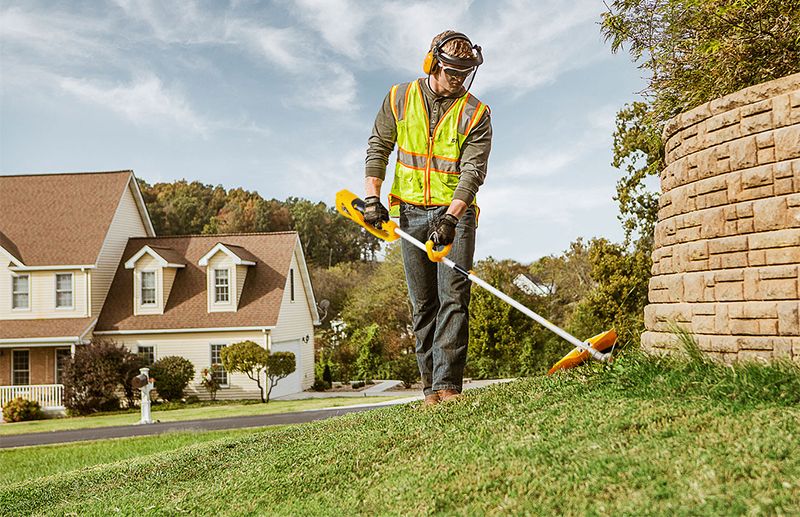 Покіс трави електричним тримером на схилі