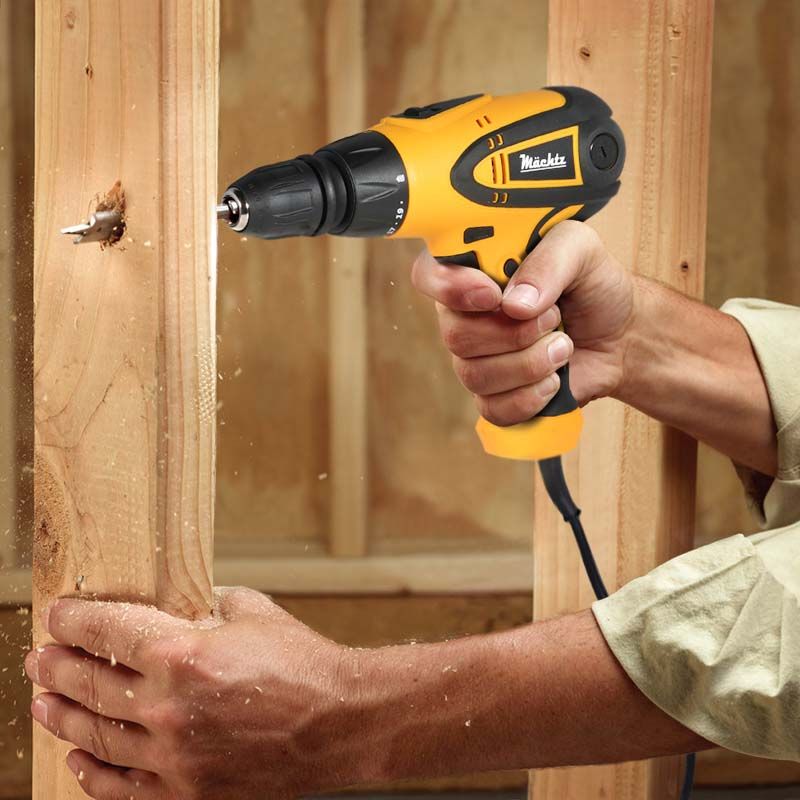 Чоловік свердлить дерев'яну балку дрилем