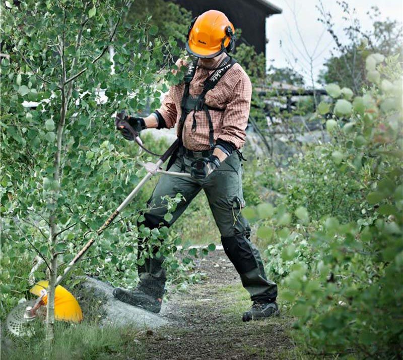 Робота бензиновим тримером у саду