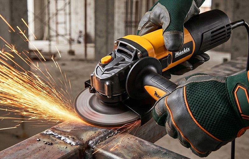 Мужчина в каске работает с болгаркой