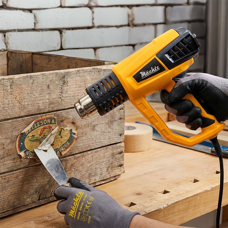 Мужчина работает строительным феном с оконной рамой