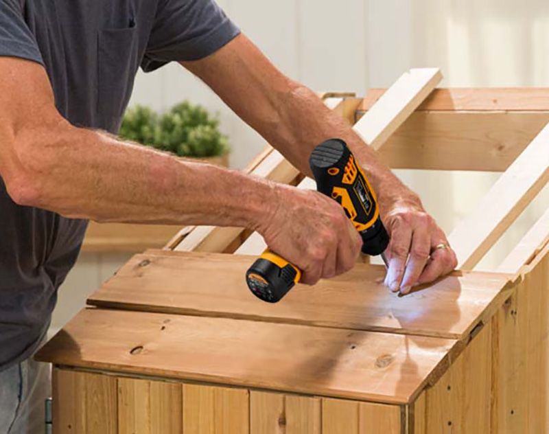 Мужчина работает шуруповертом по дереву